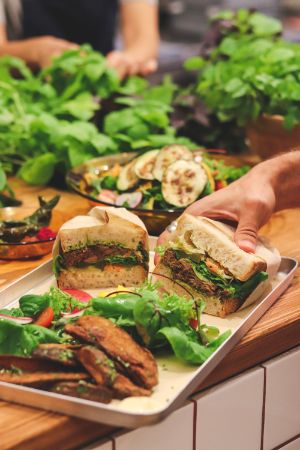 Ein Tablett mit Sandwiches, Salat und geröstetem Gemüse.
